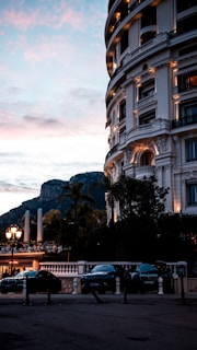 cars parked in front of a building with a mountain in the background