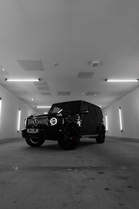a black and white photo of a jeep in a parking garage