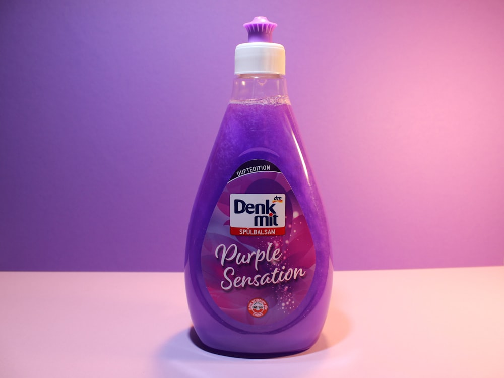 a bottle of purple liquid sitting on top of a table