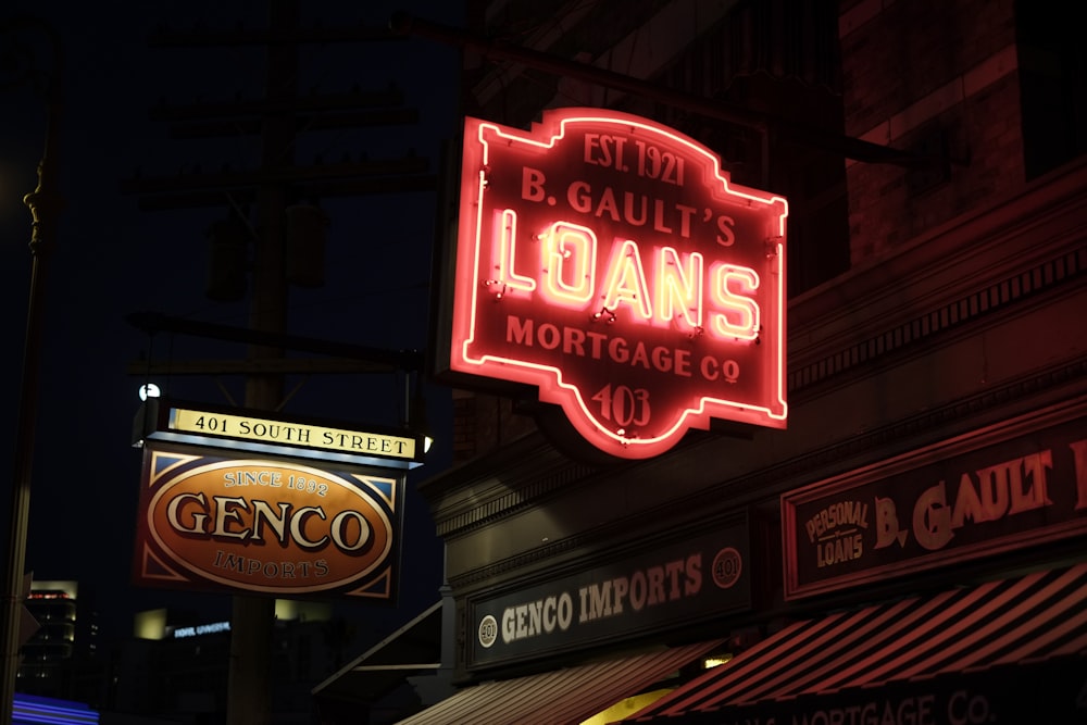 a neon sign for a bank in a city at night