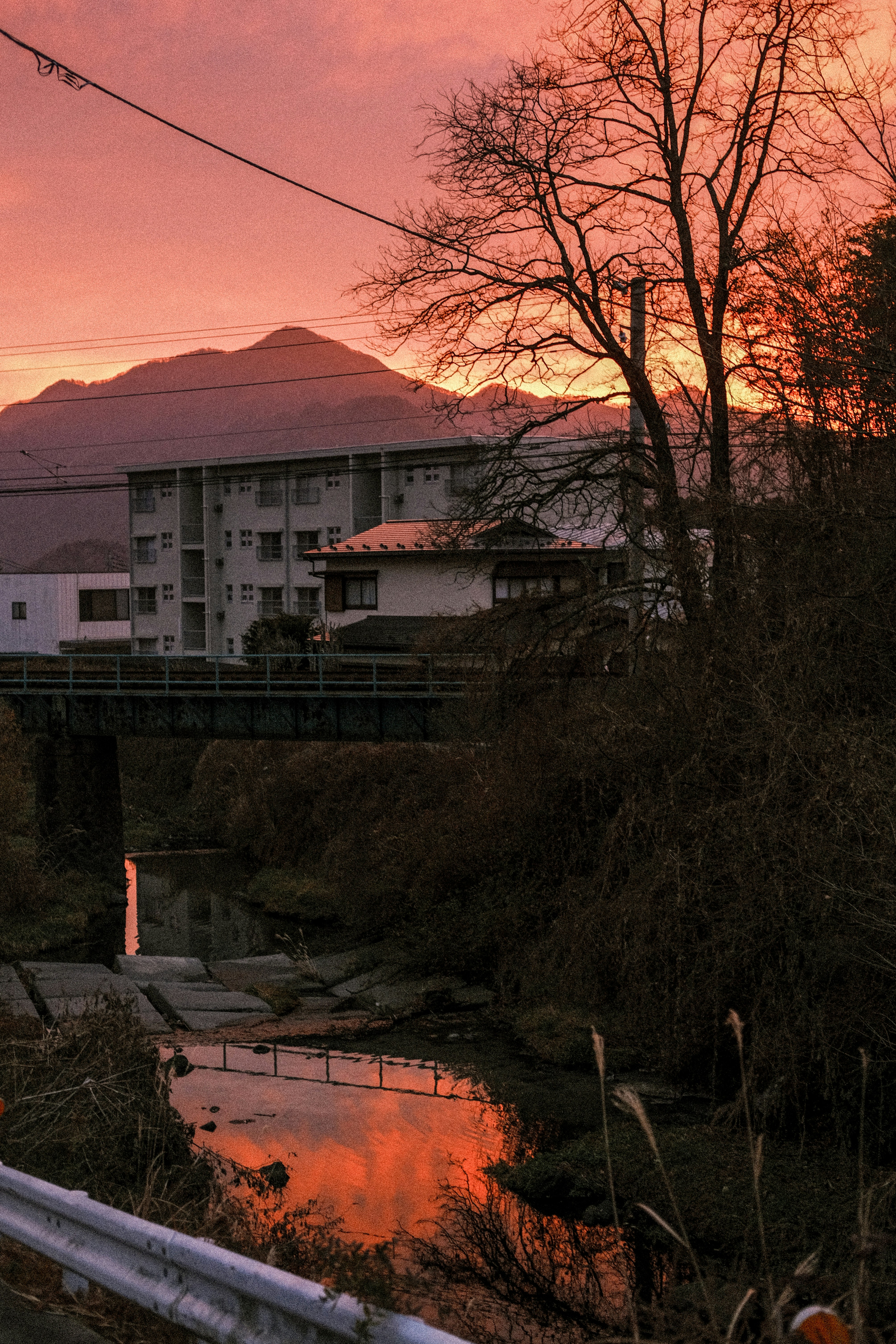 a bridge over a river with a building in the background