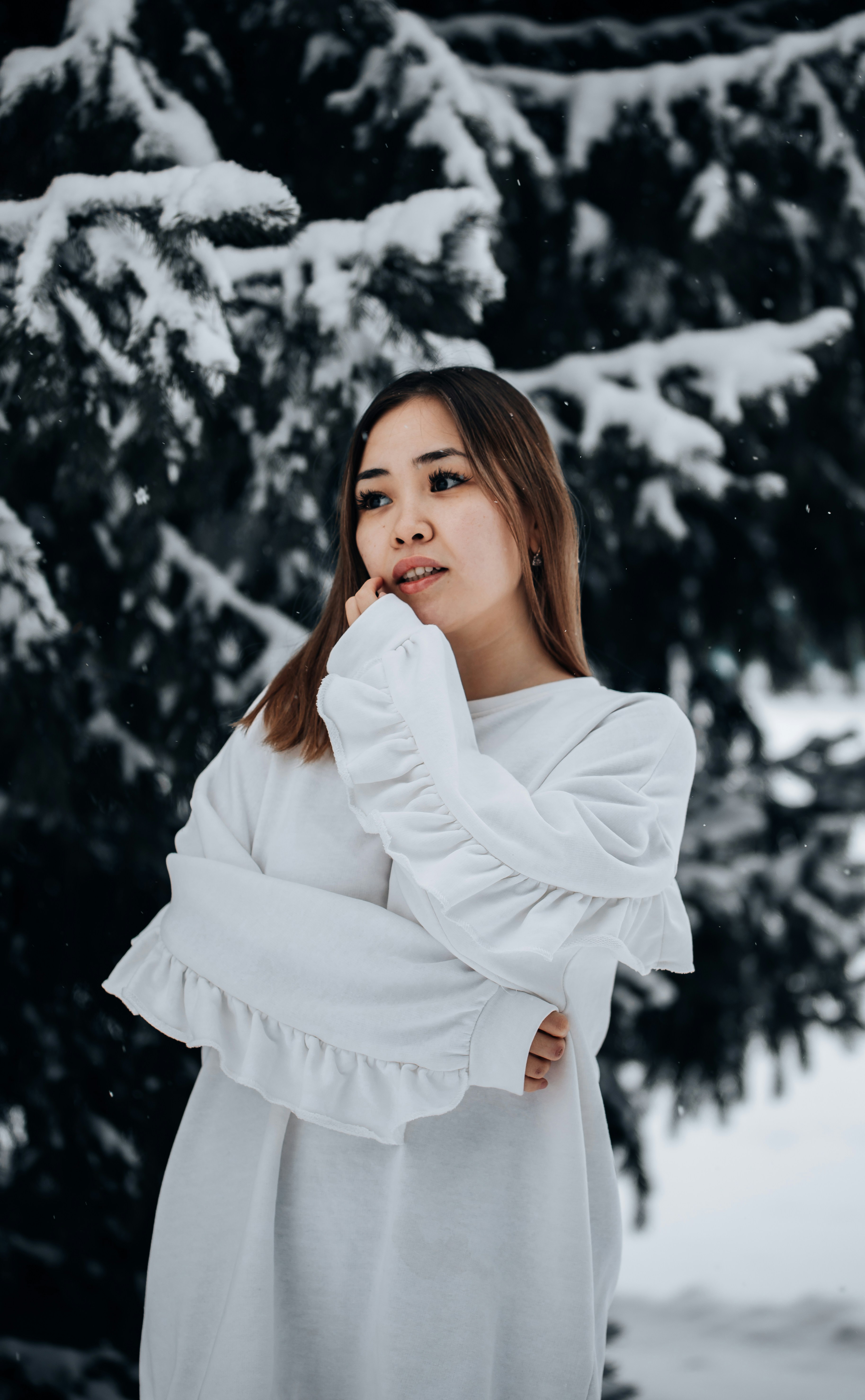 a woman standing in front of snow covered trees