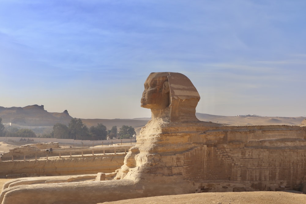 Uma grande estátua da esfinge no meio de um deserto