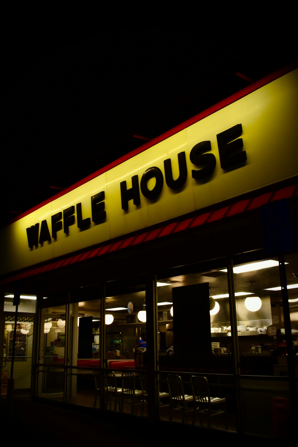 the front of a restaurant at night with a neon sign