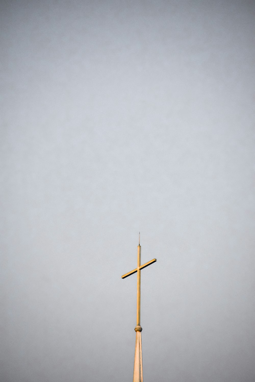 uma alta cruz de madeira no topo de um edifício