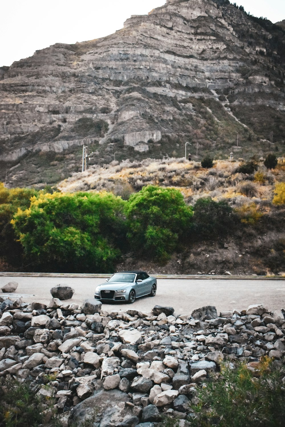 a car parked on the side of a road near a mountain