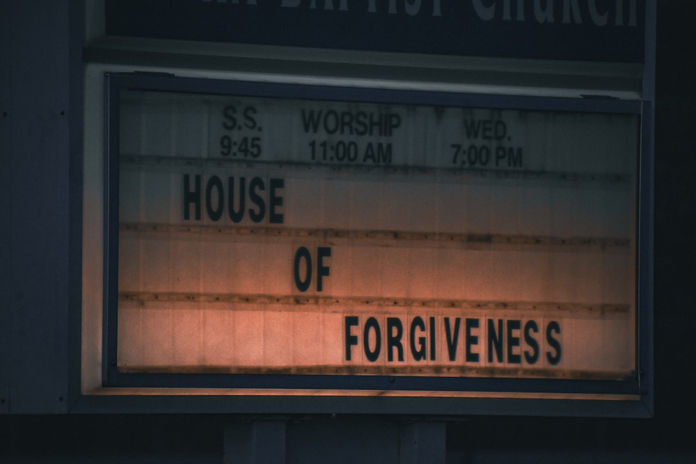 a sign that says house of forgivenes in front of a church