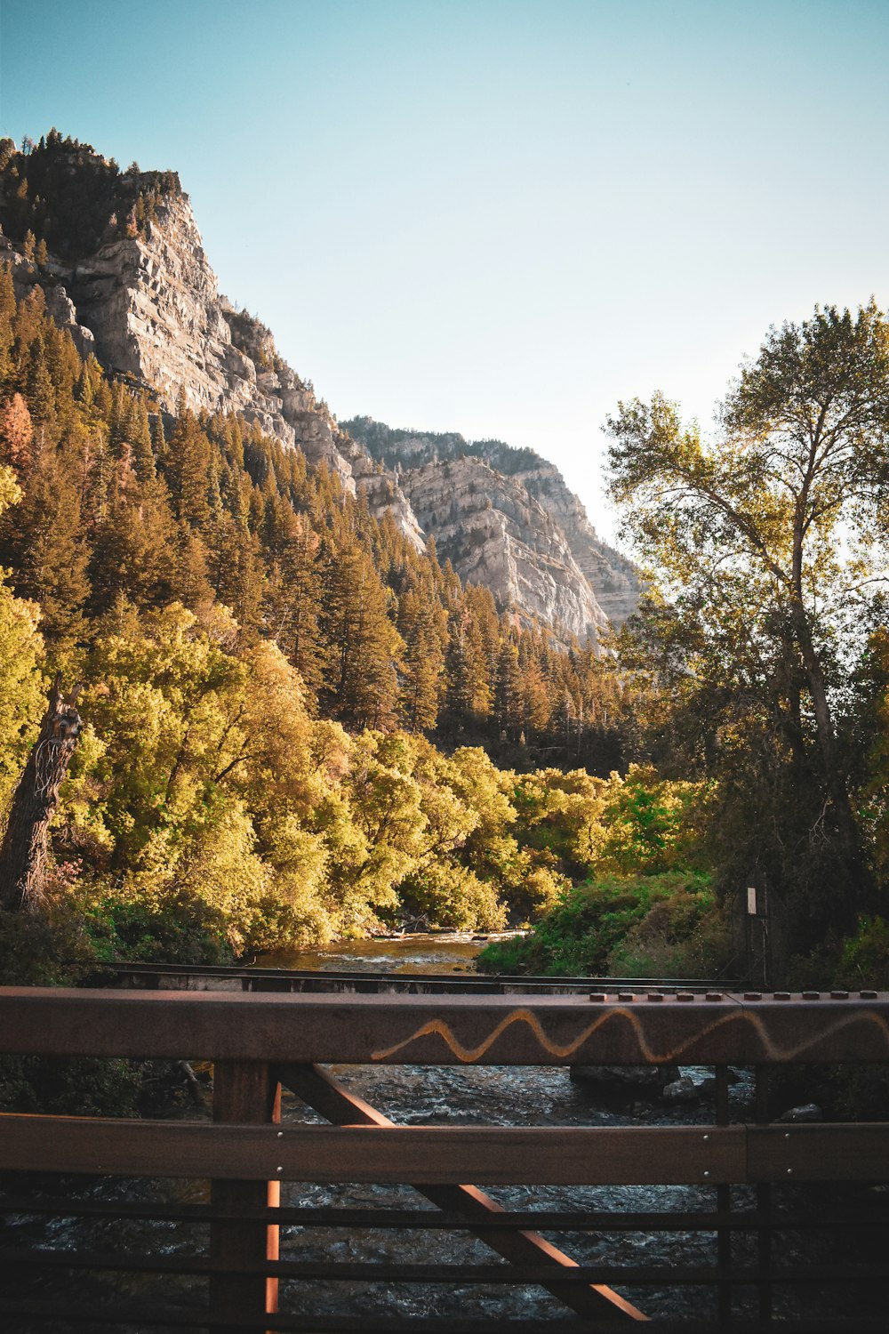 a bridge over a river with a mountain in the background