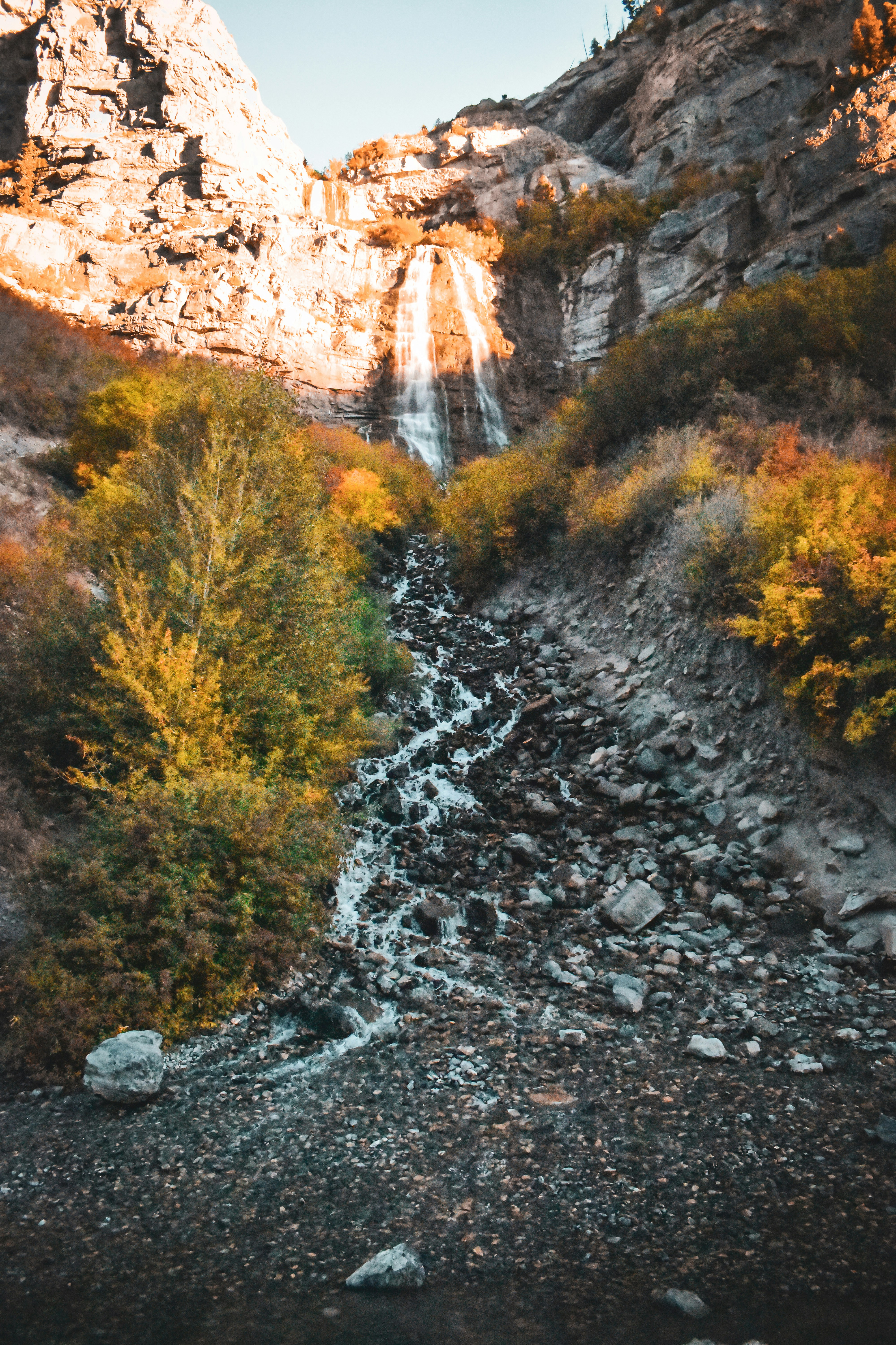 a rocky mountain with a waterfall in the background