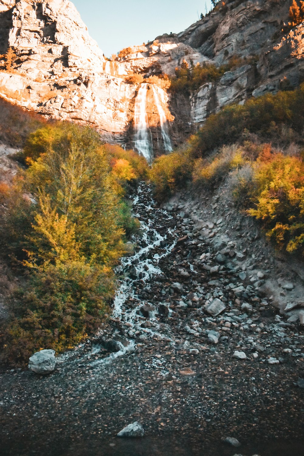 a rocky mountain with a waterfall in the background