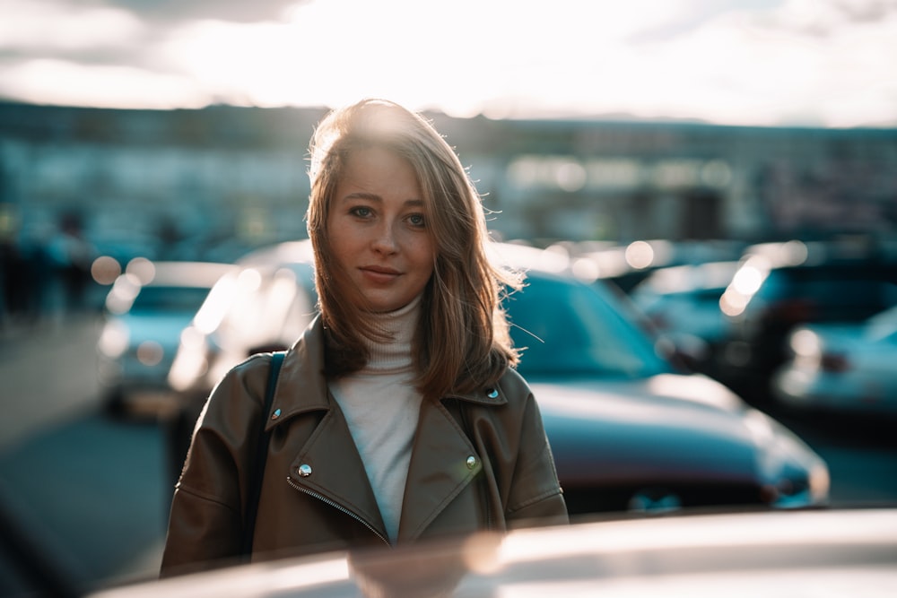 a woman standing in front of a row of parked cars