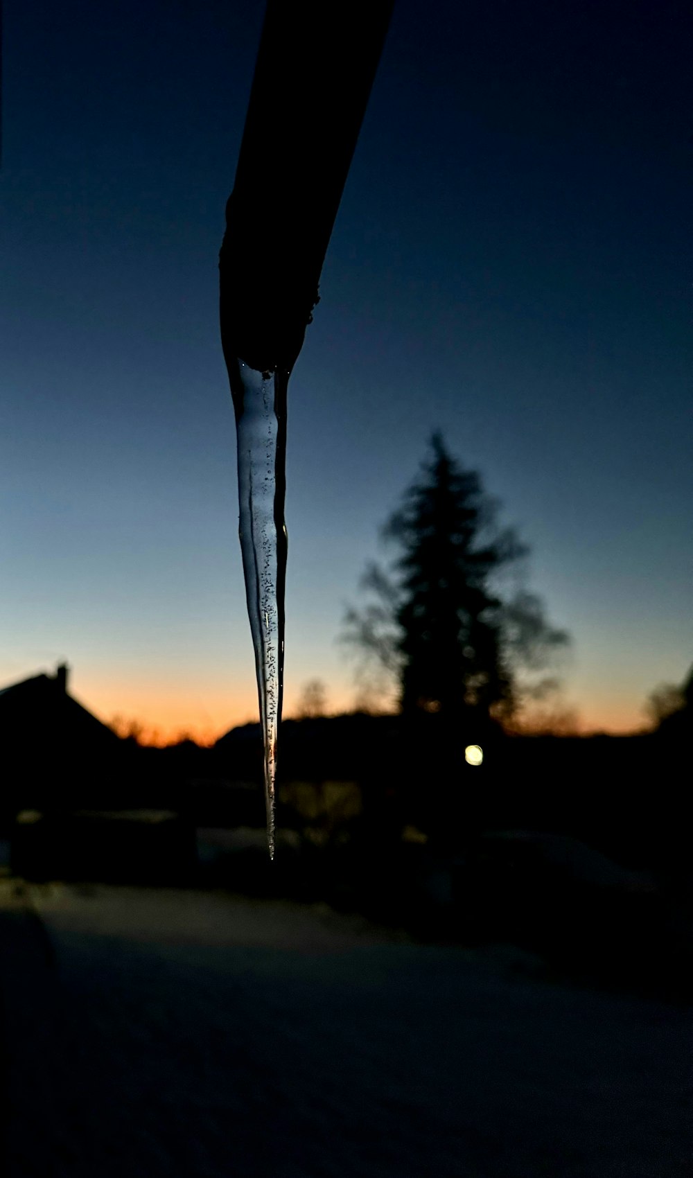 a drop of water hanging from a pipe