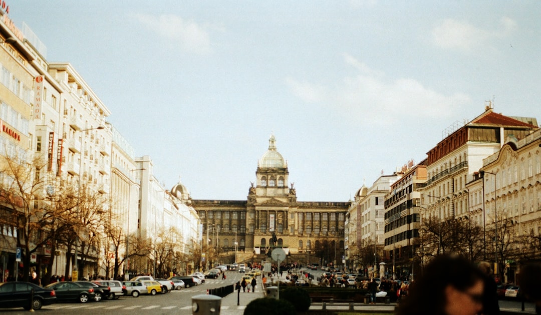 a city street filled with lots of traffic next to tall buildings, The National Museum seen from Vaclavske Namesti.