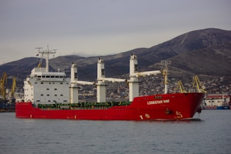 a large red and white ship in a body of water