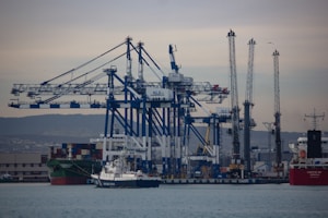 a large cargo ship in the water with a lot of cranes in the background