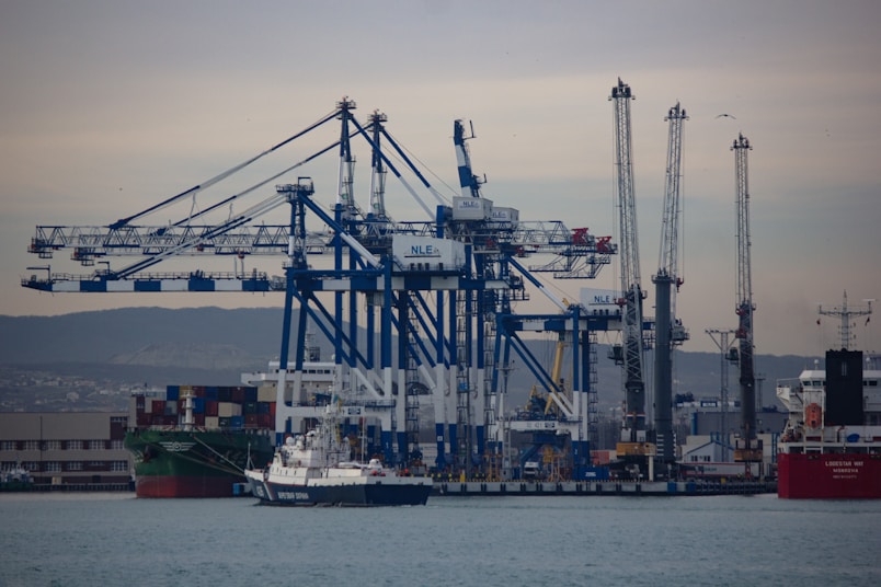a large cargo ship in the water with a lot of cranes in the background
