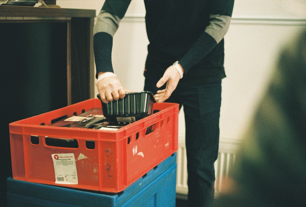 a man is putting something in a plastic container