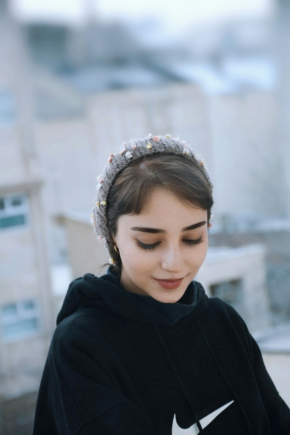 a woman wearing a black sweatshirt and a headband