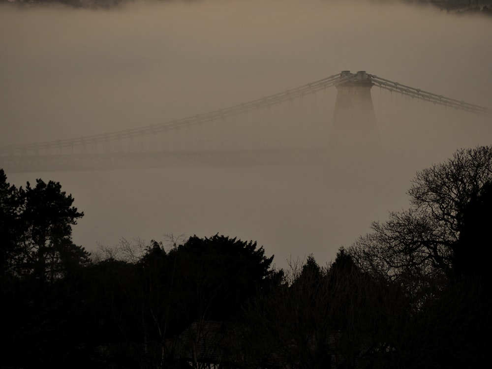 a foggy view of a bridge in the distance