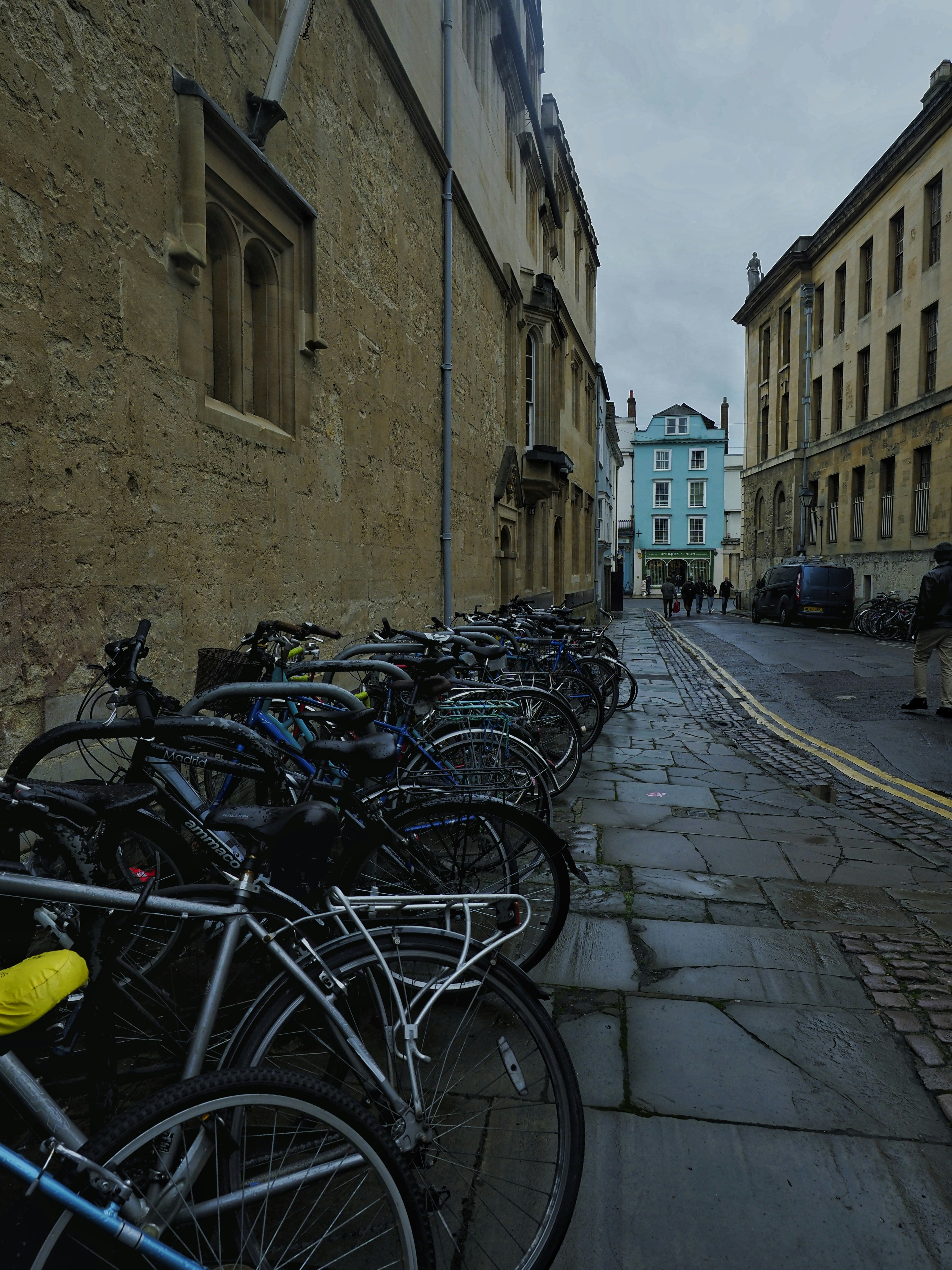 a row of bikes parked on the side of a street