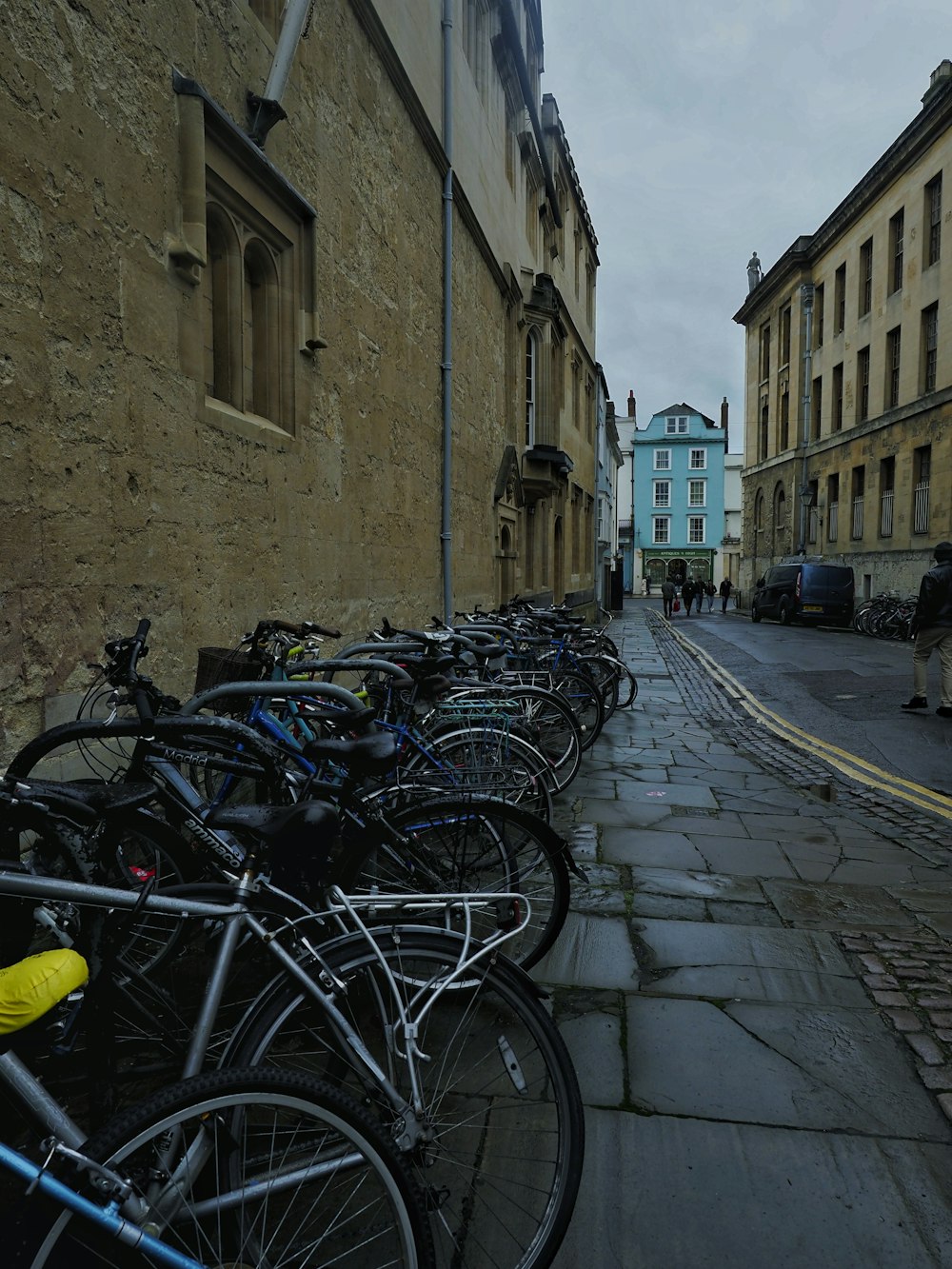 a row of bikes parked on the side of a street