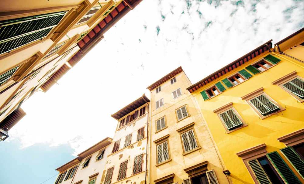 looking up at a building with green shutters