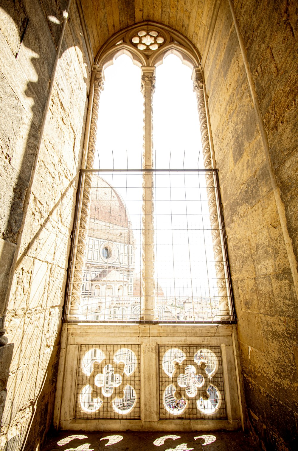 a window in a stone building with a view of a dome