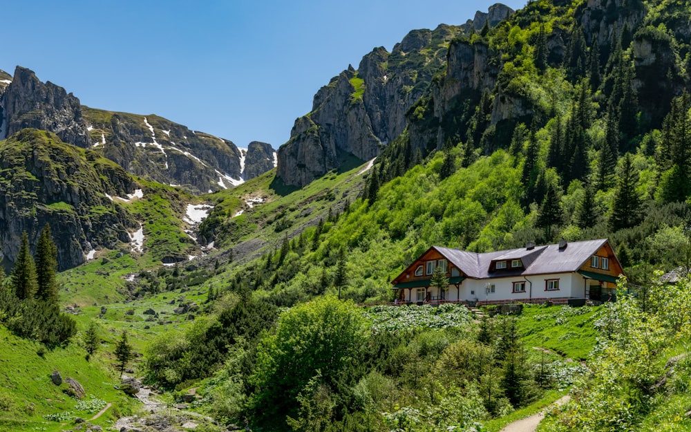 a house in the middle of a lush green valley