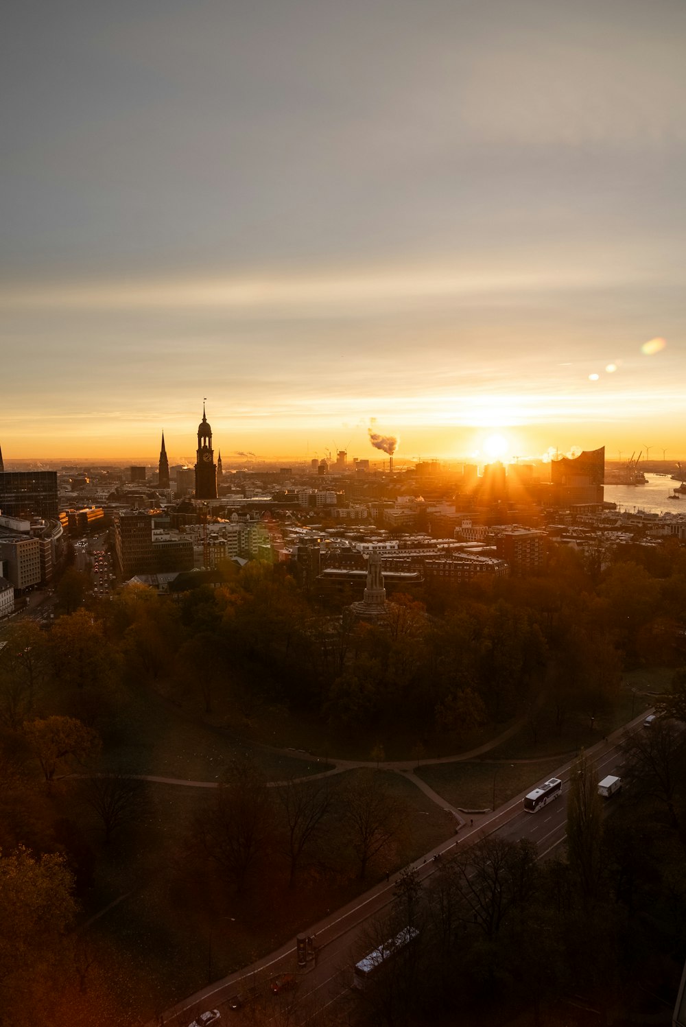 the sun is setting over a city with tall buildings