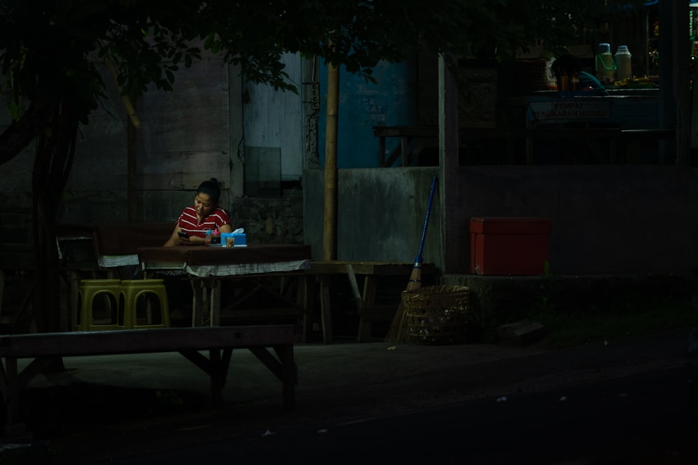 um homem sentado em uma mesa no escuro