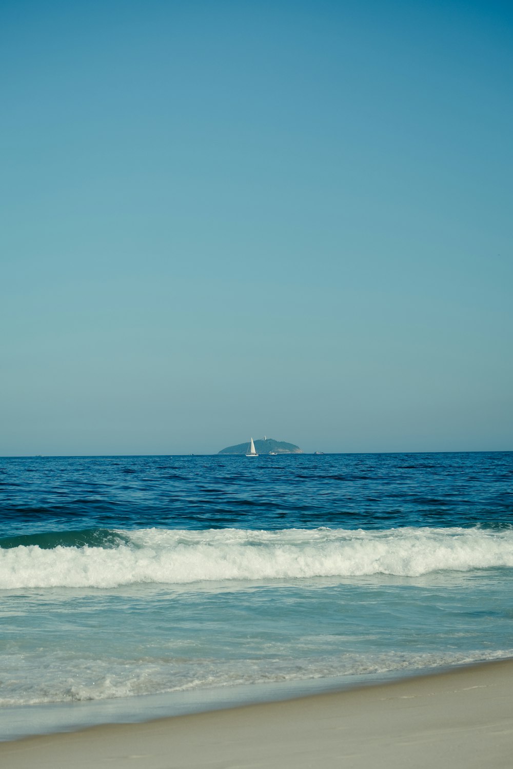 a sailboat is in the distance on the ocean