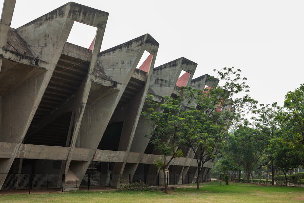 a large concrete building sitting next to a lush green park