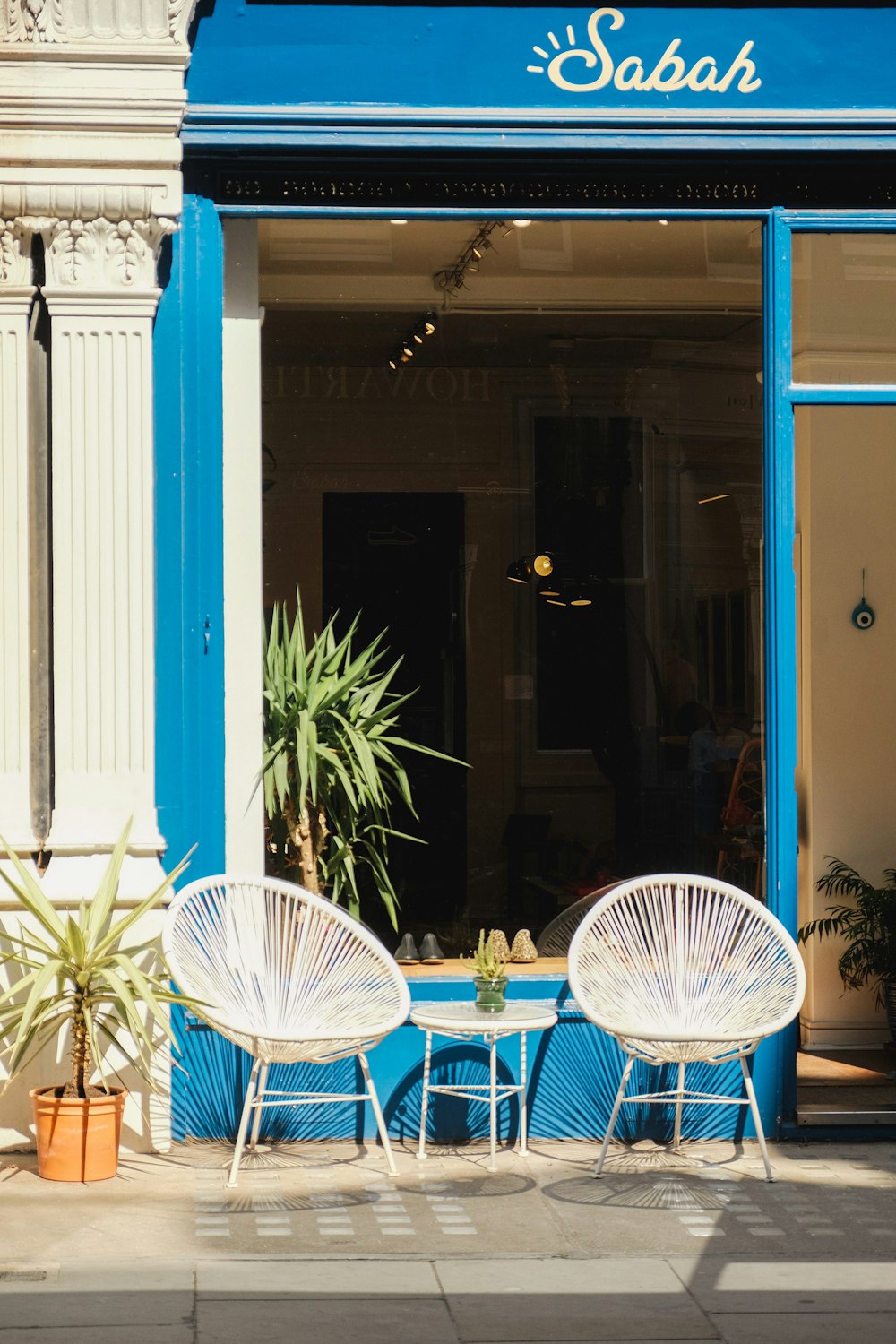 a couple of white chairs sitting outside of a store