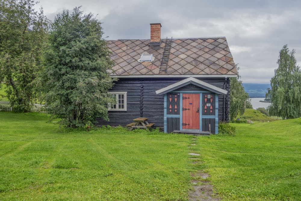 a small blue cabin with a red door