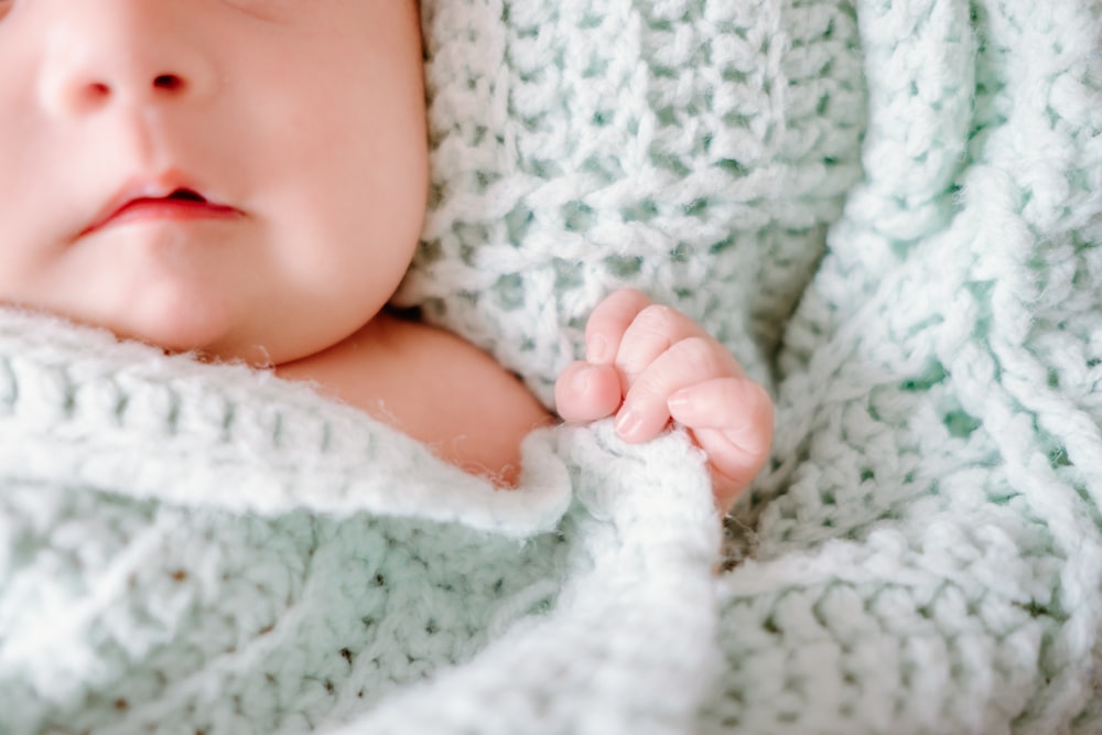 a close up of a baby wrapped in a blanket