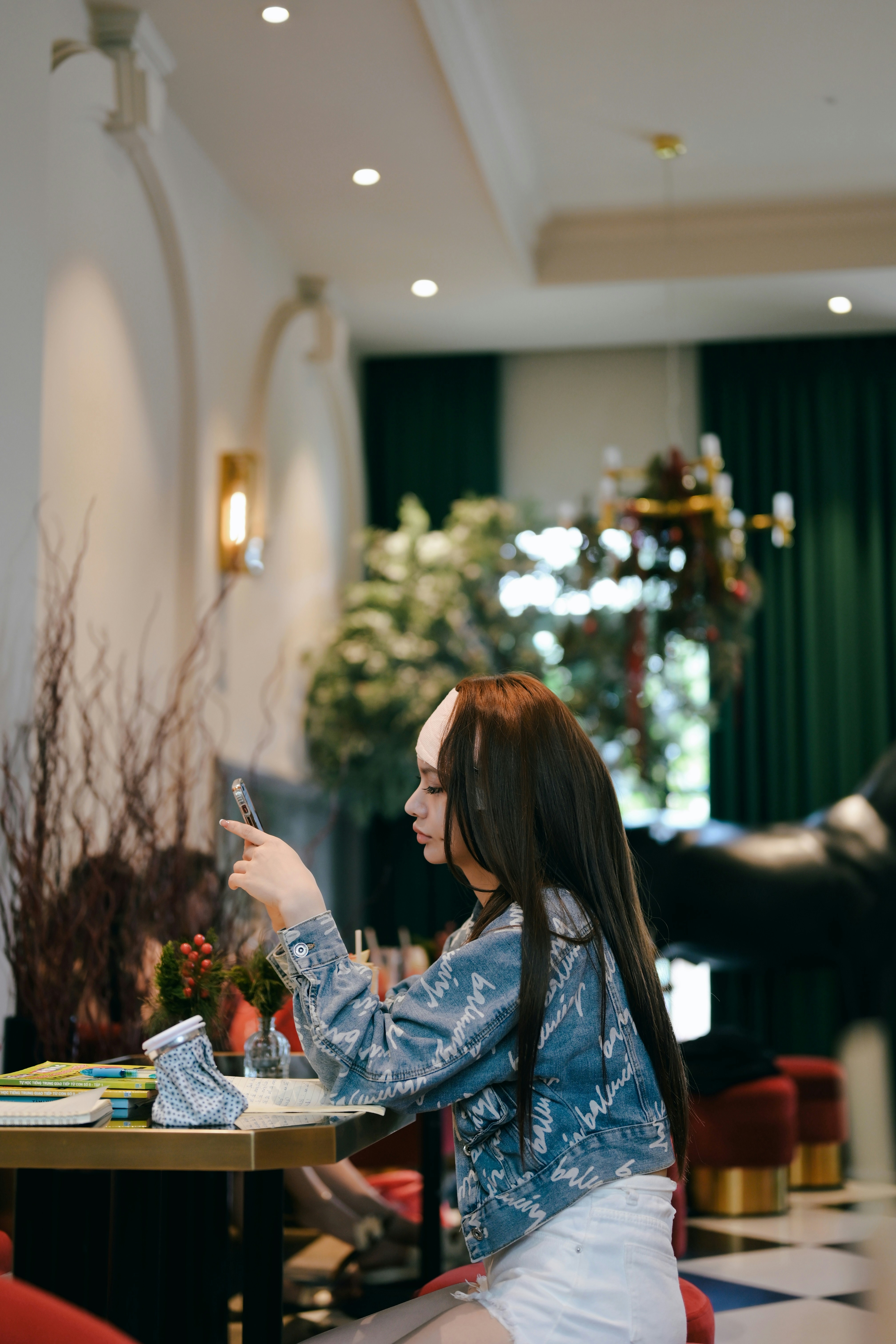 a woman sitting at a table with a cell phone