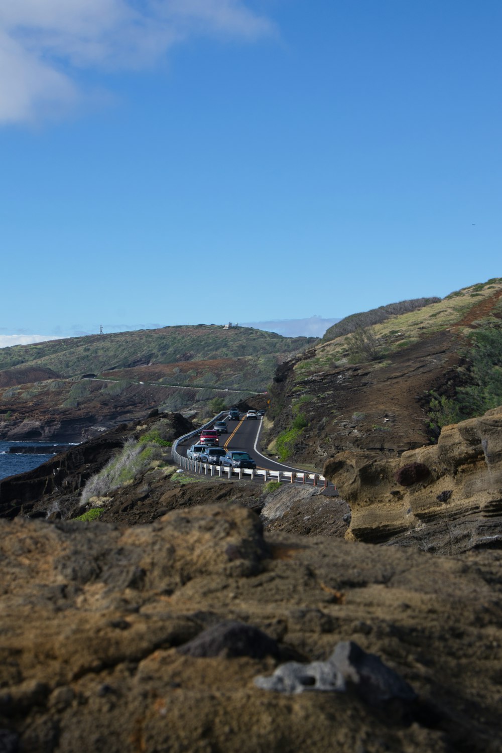 a car driving down a road next to the ocean