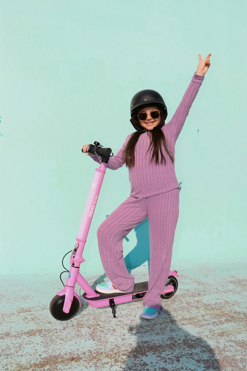 a woman in a pink outfit riding a pink scooter