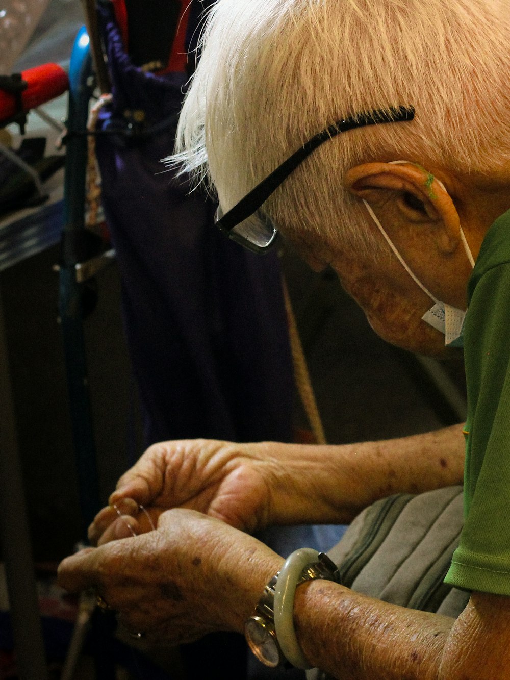 an old man wearing glasses and a green shirt