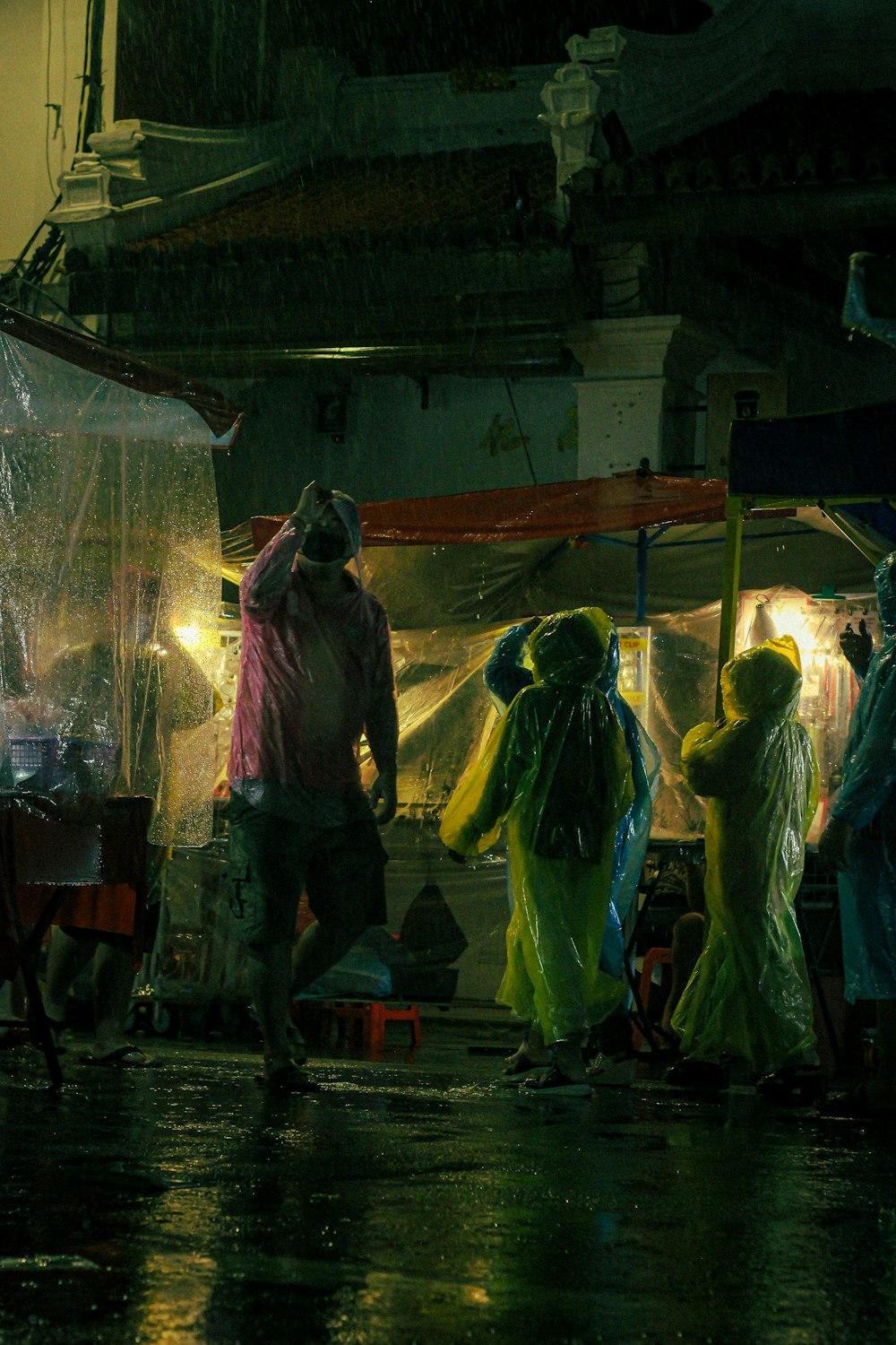 a group of people walking down a street in the rain