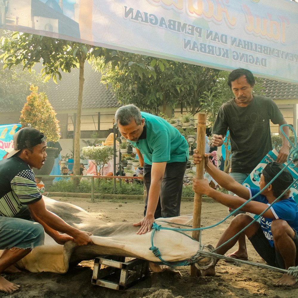 a group of men working on a piece of wood