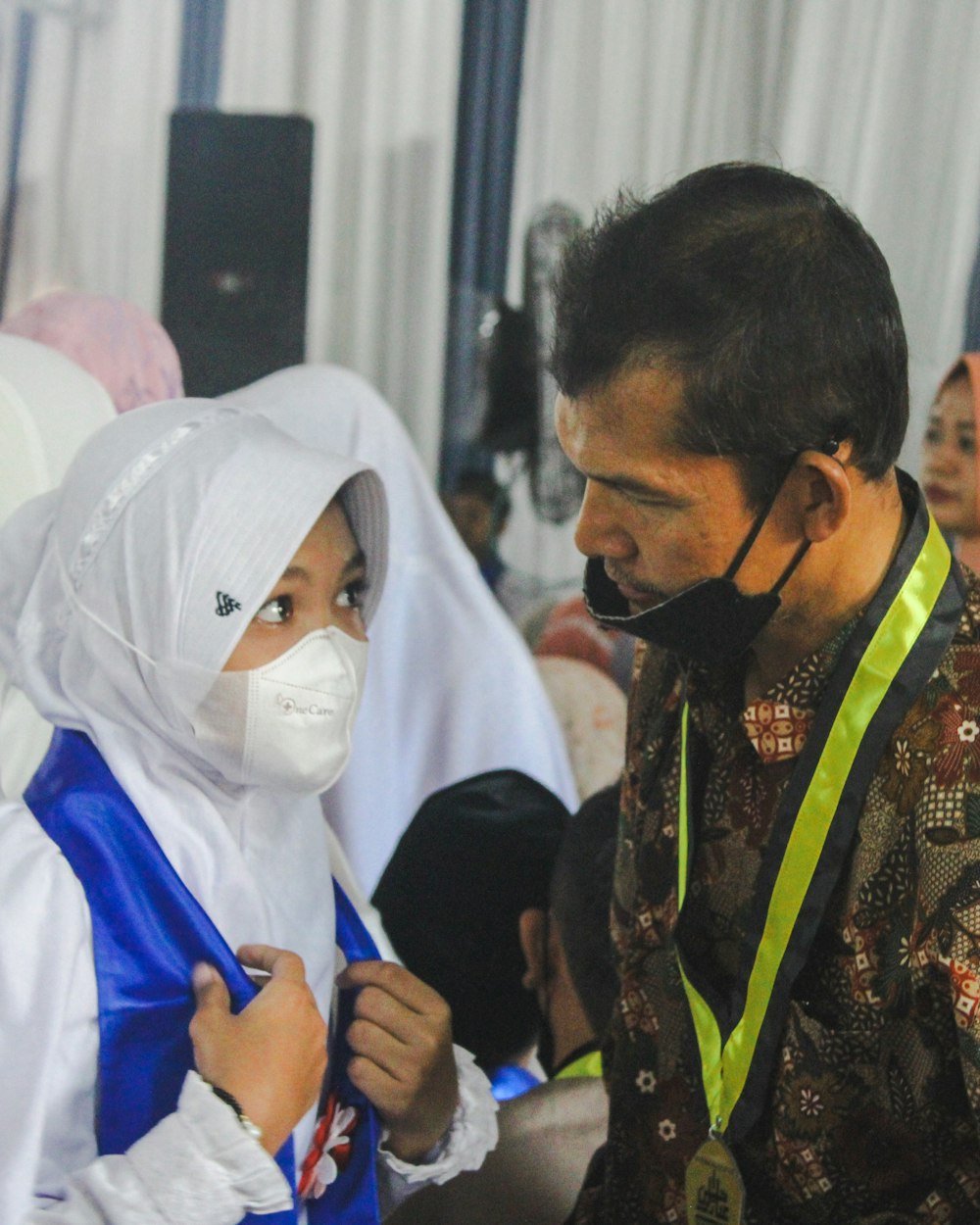 a man wearing a face mask while standing next to a woman
