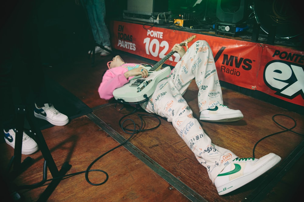 a person laying on the ground with a guitar