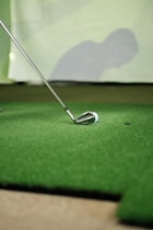 a golf ball and a golf club on a putting green