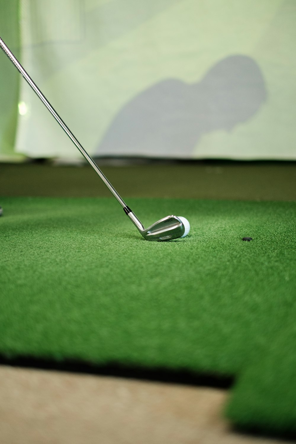 a golf ball and a golf club on a putting green