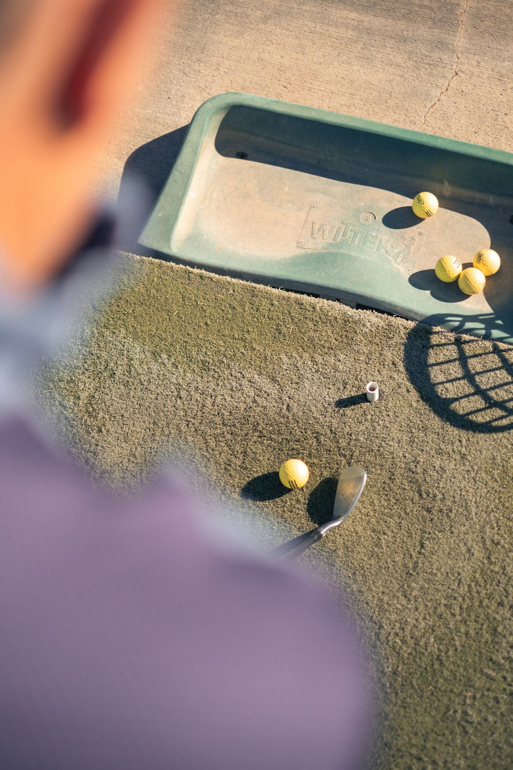 a man standing next to a playground filled with balls