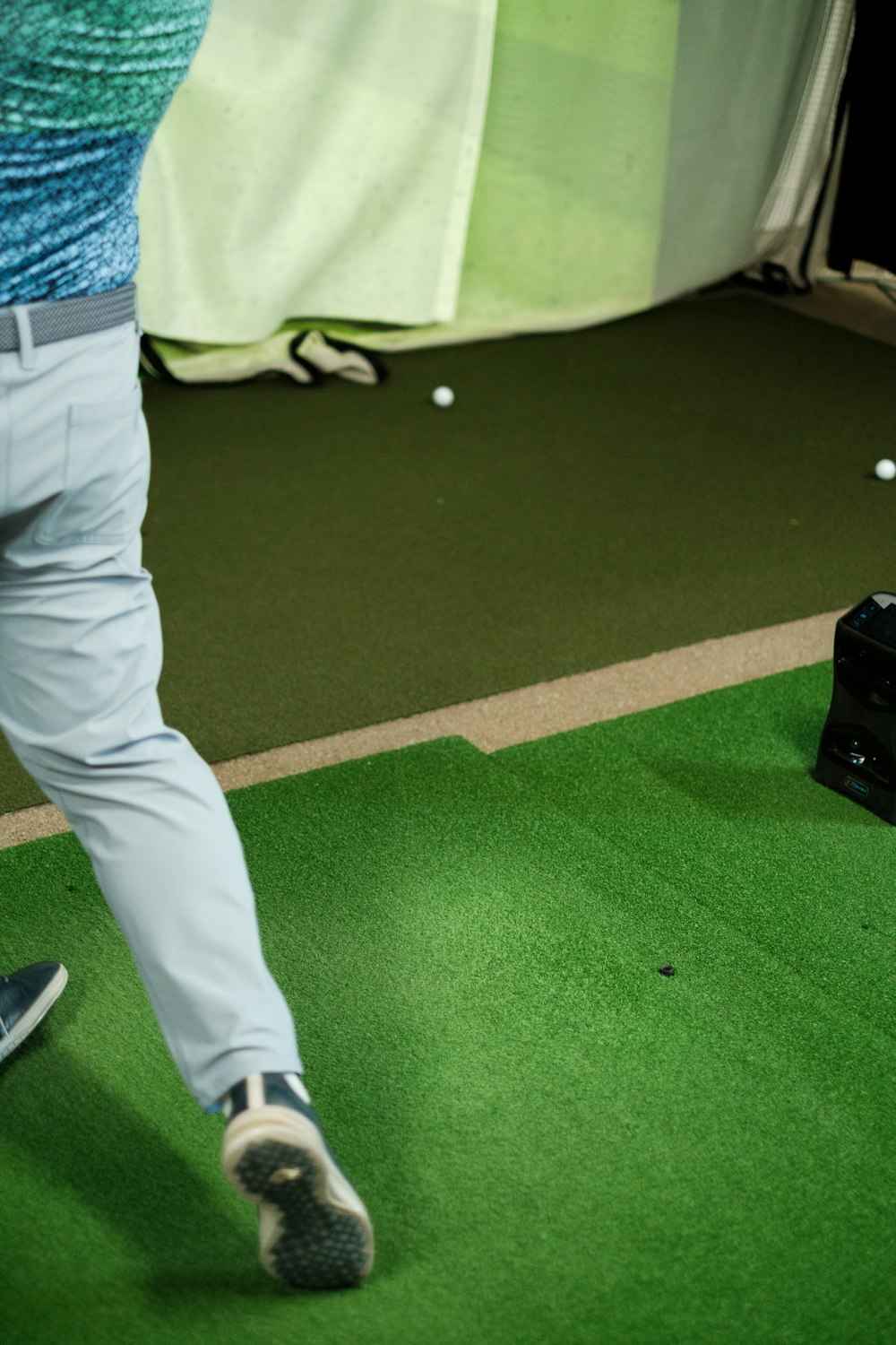 a man in blue shirt and grey pants playing a game of golf