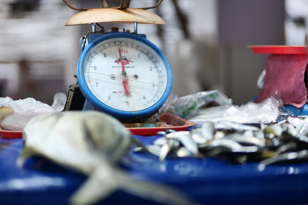 a blue table topped with lots of junk and a clock