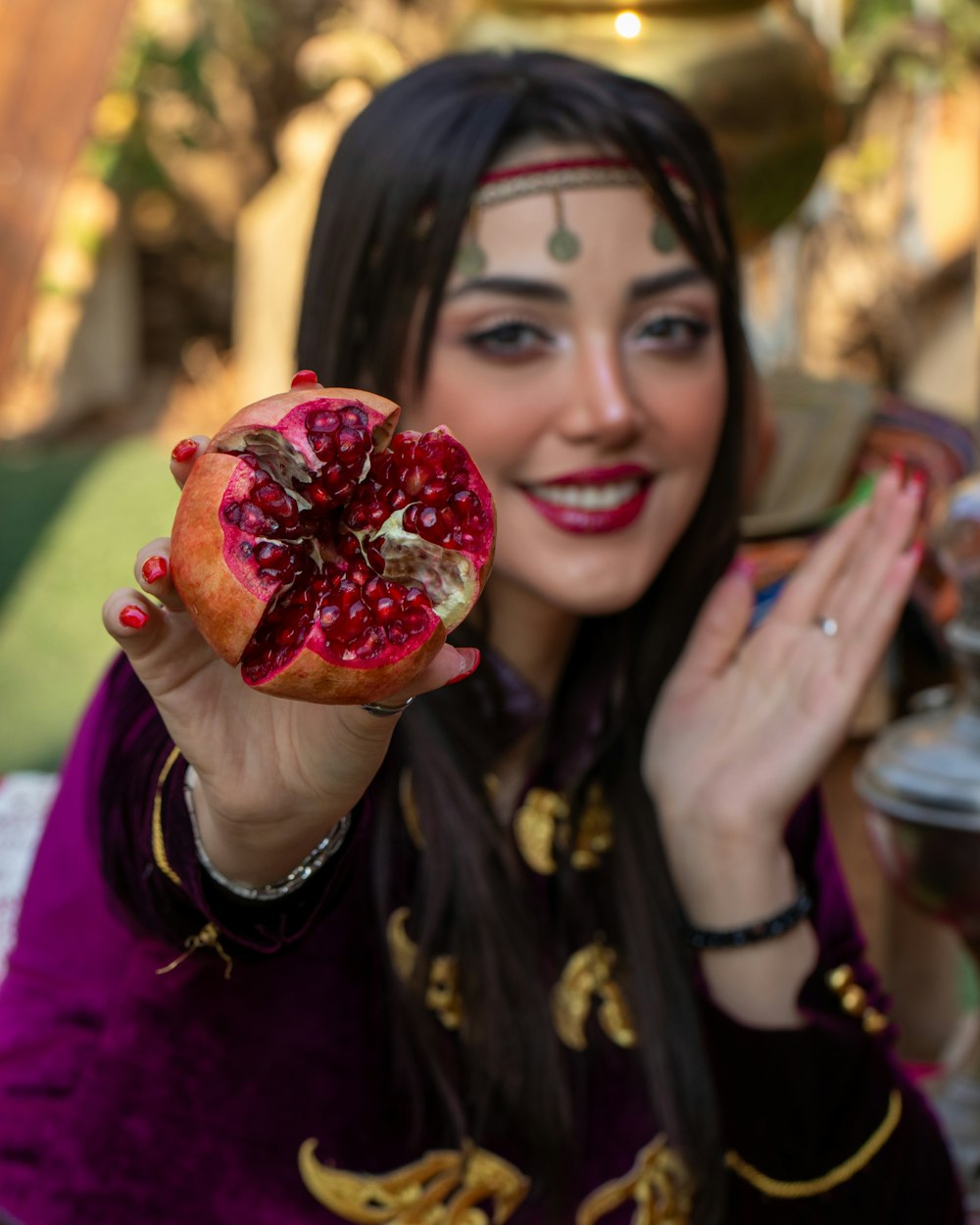 a woman holding a pomegranate in her hand