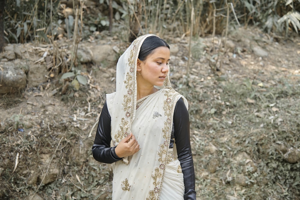 a woman in a white and gold sari